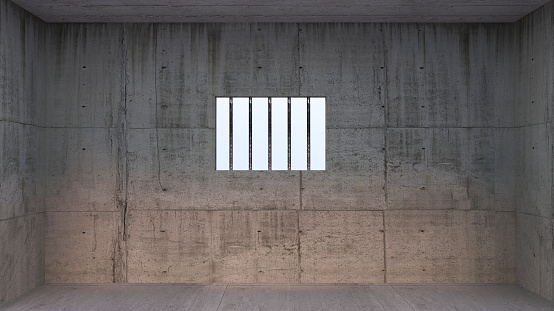 Prison cell with light shining through a barred window